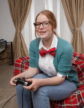 nerdy child playing with a games console controller 