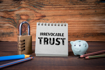Irrevocable trust. Cardboard notepad on wooden texture table