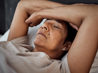 Fototapeta na wymiar Sleeping, headache and senior woman in home bedroom with fatigue, tired or exhausted. Depression, insomnia and elderly person in bed with pain, stress and problem, anxiety or crisis in retirement