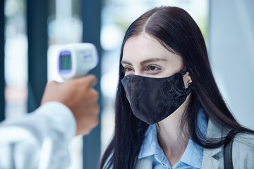 Doctor, covid and thermometer for healthcare scan to test patient temperature or check for fever or symptoms. Businesswoman with corona mask in exam, scanning face with infrared scanner at the office