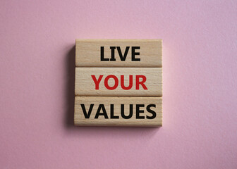 Live your values symbol. Concept words Live your values on wooden blocks. Beautiful pink background. Business and Live your values concept. Copy space.