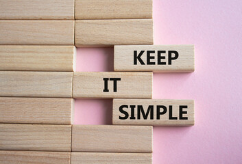 Keep it Simple symbol. Concept words Keep it Simple on wooden blocks. Beautiful pink background. Business and Keep it Simple concept. Copy space.