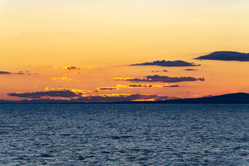 orange sunset on sea and blue clouds