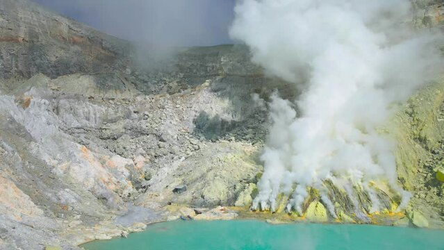 The sulfuric lake of Kawah Ijen vulcano in East Java with sulfur stone in foreground, Indonesia