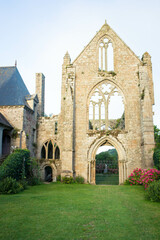 Fototapeta na wymiar The main facade of Beauport Abbey, a roofless gothic building located in Paimpol, Cotes d'Armor, Brittany, France. August 2023, sunset view. vertical shot.