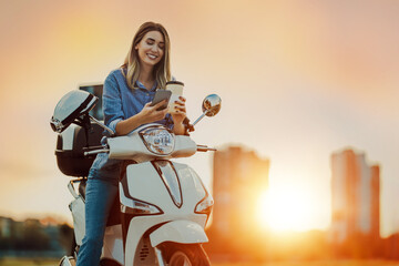 Portrait of happy woman riding on motorbike in city street