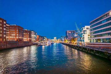 Hamburg, Germany. The Harbor District (HafenCity) at night. Sandtorkai and Kaiserkai across the traditional port Sandtorhafen.