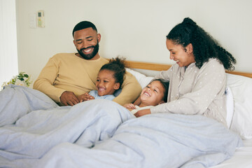 Happy family, wake up and playing in bed in the morning, bond and having fun in their home...