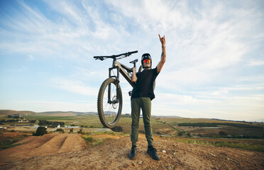 Hand sign, mountain bike and man outdoor in nature for extreme sports, training or workout. Rock...