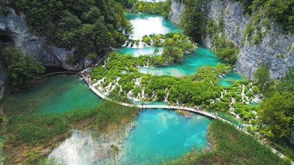 Hiking trail over crystal clear emerald water of lake. Path for tourists in mountain national park with waterfalls. Plitvice Croatia. © Olga Gorkun
