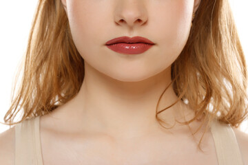 Beauty face makeup closeup. Womans lower jaw with red lips wearing color lipstick. Closed mouth,...