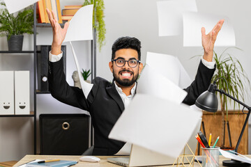 Displeased freelancer man throws paper bills. Stressed Indian businessman working looking at unpaid...