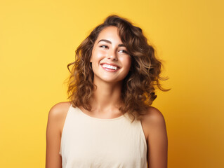 Closeup photo portrait of a young european woman smiling. Isolated on yellow background.