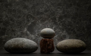 minimalist composition of natural stones for product presentation. zen stones for the podium on a dark background. cosmetology perfumery medicine skin care hygiene products concept.