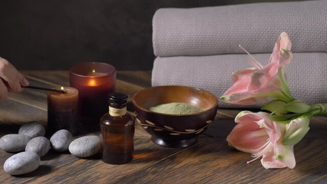 Beauty spa treatment with oils, laminaria algae in bowl and candles on dark background