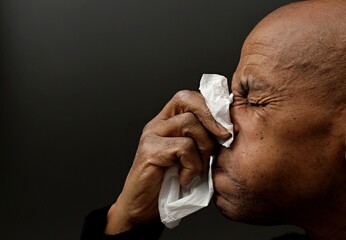 blowing nose after catching the flu and cold with grey background with people stock image stock...