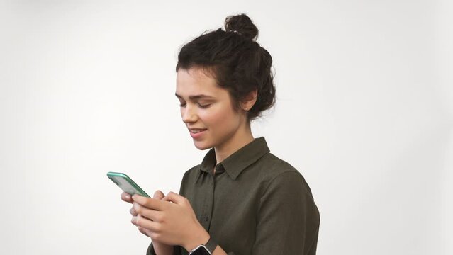Young woman using smartphone isolated on white background. Looking at cellphone texting with friend. Check social media. Enjoying mobile technology and reading news. planning holiday weekend