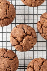 Chocolate brownie cookies with crack on cooling rack on white background. Homemade crinkle cookies