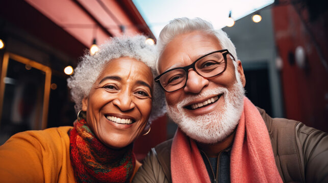 Multiracial elderly couple with gray hair taking selfie in the city. Enjoying time together.