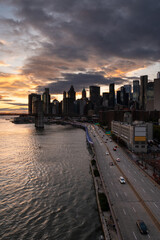 Amazing dramatic sunset over Manhattan skyline featuring Brooklyn Bridge over East River in October