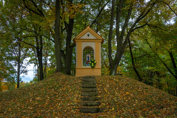 Chapel and leaf tree alley near Vltava river in autumn cloudy evening