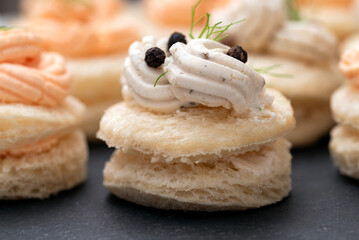 Primo piano di deliziose canapès condite con mousse di formaggio e salmone, antipasti europei 
