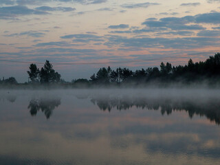 Fog over the lake in the morning. Sunrise.