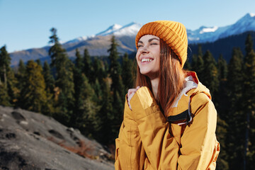 Woman smile with teeth happiness and laughter tourist in yellow raincoat travel in the fall and hiking in the mountains in the sunset sunshine freedom