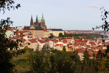 Obraz premium Autumn Prague City with gothic Castle, colorful Nature and Trees with blue Sky from the Hill Petrin, Czech Republic