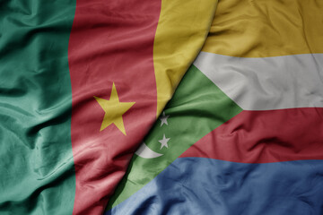 Obraz premium big waving national colorful flag of cameroon and national flag of comoros .