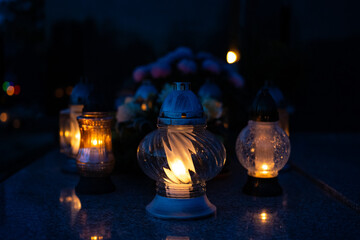 Candle light in the cemetery at night. Selective focus.All saint's day.  Lanterns in the cemetery at night.Lantern on the background of burning candles in the night.