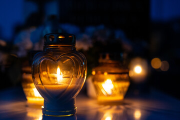 Candle light in the cemetery at night. Selective focus.All saint's day.  Lanterns in the cemetery at night.Lantern on the background of burning candles in the night.
