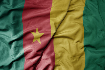 Obraz premium big waving national colorful flag of cameroon and national flag of guinea .
