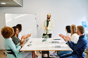 Coworkers applauding the presentation of a project of a man