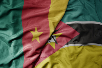 big waving national colorful flag of cameroon and national flag of mozambique .
