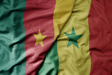 big waving national colorful flag of cameroon and national flag of senegal .
