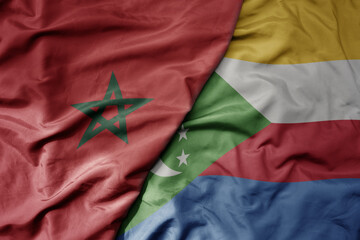 big waving national colorful flag of morocco and national flag of comoros .