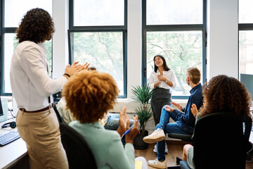 Asian woman talking during a relaxed meeting on a coworking - obrazy, fototapety, plakaty