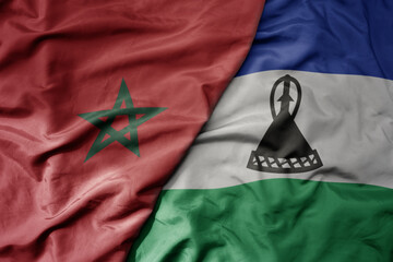 big waving national colorful flag of morocco and national flag of lesotho .