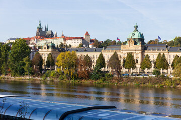 Autumn colorful Prague Lesser Town with gothic Castle above River Vltava in the sunny Day, Czech...