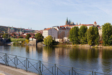 Fototapeta premium Autumn colorful Prague Lesser Town with gothic Castle above River Vltava in the sunny Day, Czech Republic