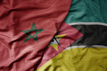 big waving national colorful flag of morocco and national flag of mozambique .