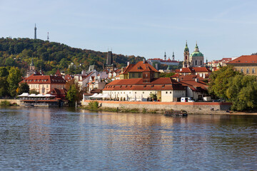 Autumn colorful Prague Lesser Town with gothic Castle above River Vltava in the sunny Day, Czech Republic