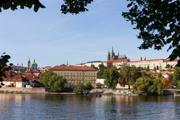 Autumn colorful Prague Lesser Town with gothic Castle above River Vltava in the sunny Day, Czech...