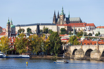 Autumn colorful Prague Lesser Town with gothic Castle above River Vltava in the sunny Day, Czech...