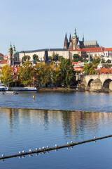 Autumn colorful Prague Lesser Town with gothic Castle above River Vltava in the sunny Day, Czech...