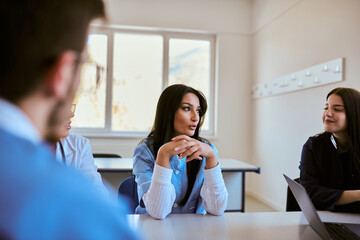Obraz premium A dedicated group of doctors and medical nurses attentively listens to their colleague's work plan in a healthcare facility, fostering collaboration and ensuring high-quality patient care
