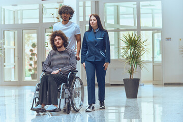 A doctor and a nurse work together to transport a patient in a wheelchair through a modern...