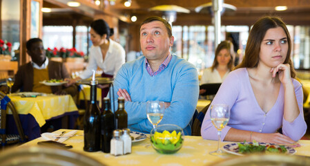 Caucasian man having quarrel with his girlfriend during date in restaurant.