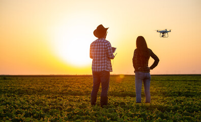 Farmers driving drone above field - 671852823